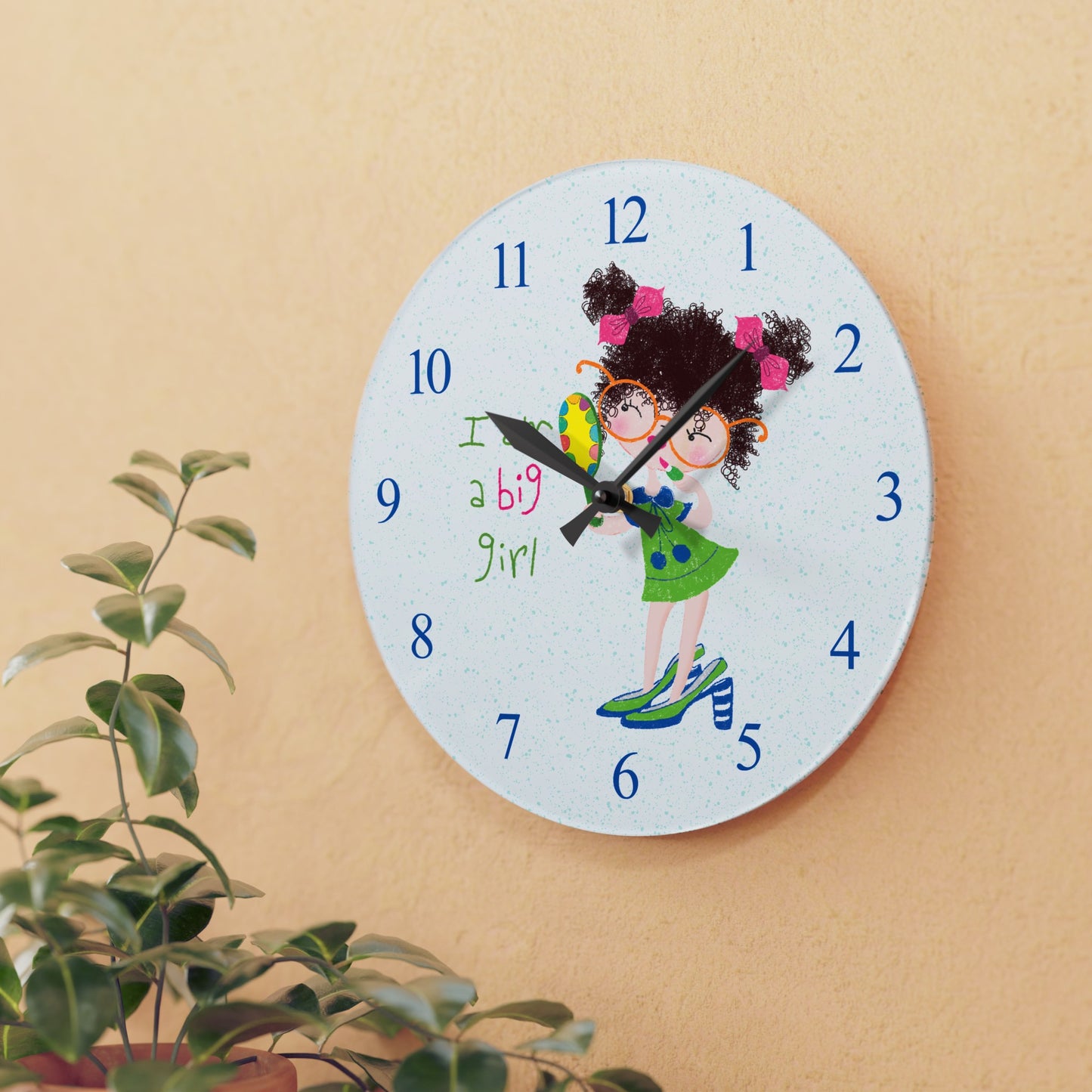 Humorous nursery acrylic wall clock featuring a cartoon girl with curly hair, oversized glasses, and a green dress, holding a mirror, with the text 'I am a big girl' alongside blue numbers on the clock face - on the wall, size 10.75”x10.75” (round ), close-up, kidlic