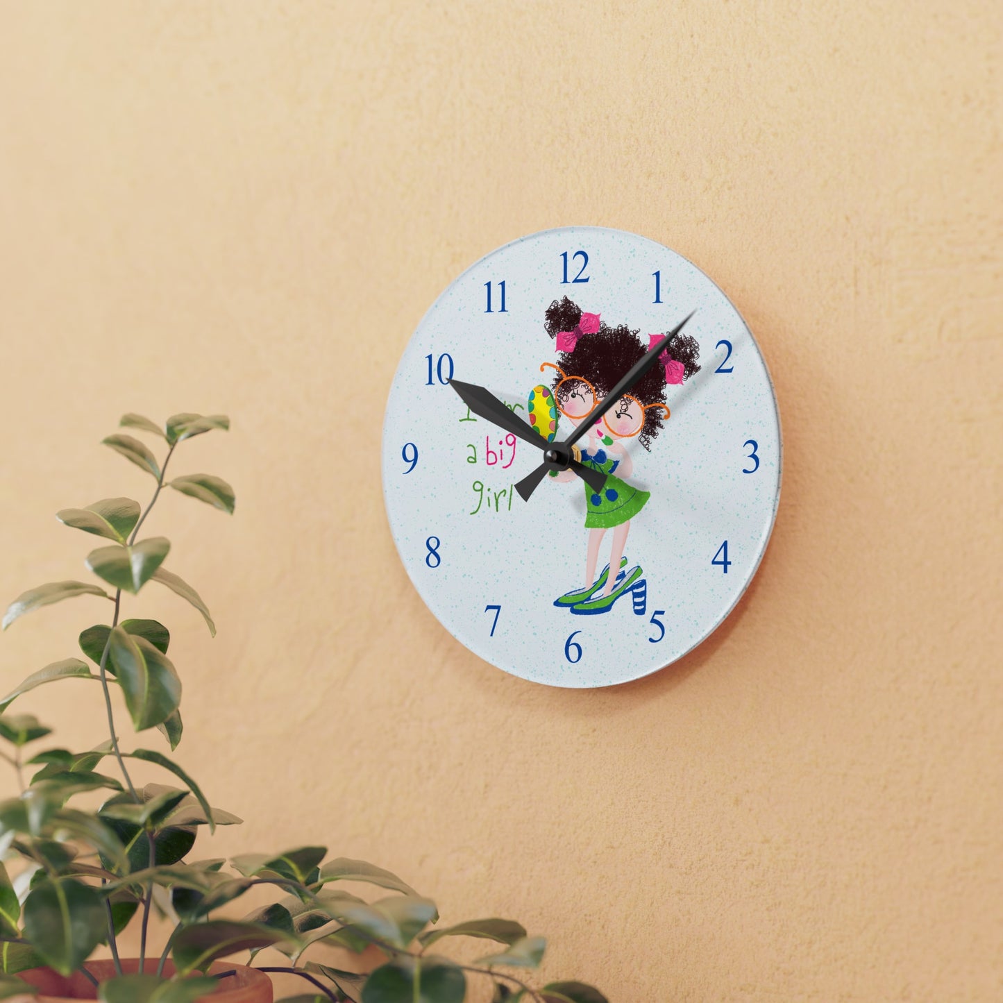 Humorous nursery acrylic wall clock featuring a cartoon girl with curly hair, oversized glasses, and a green dress, holding a mirror, with the text 'I am a big girl' alongside blue numbers on the clock face - on the wall, size 8”x8” (square ), close-up, kidlic