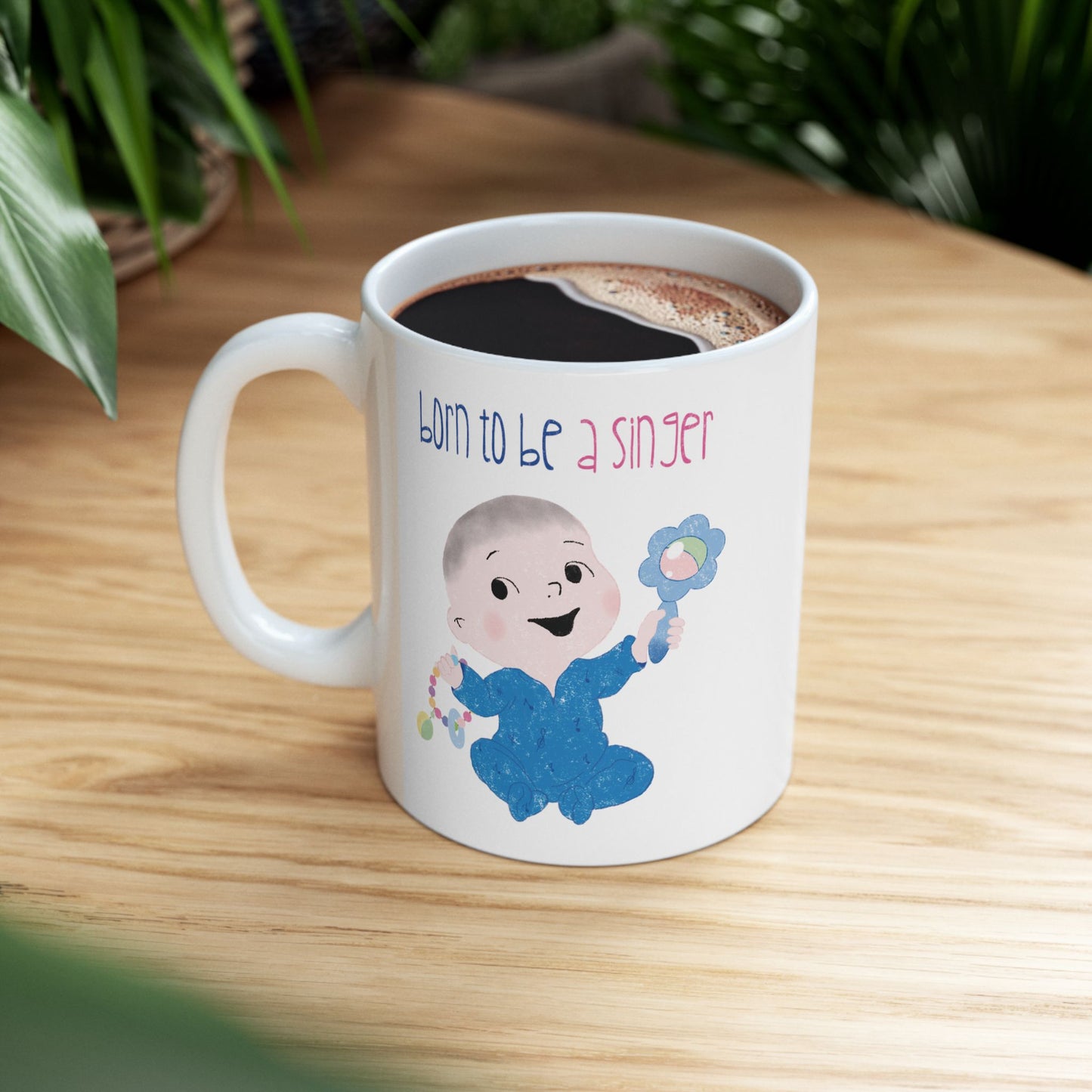 Playful nursery coffee mug featuring a cartoon baby boy holding a rattle, with the text "Born to be a singer”, on a small table, size: 11oz, free shipping , USA, Kidlic