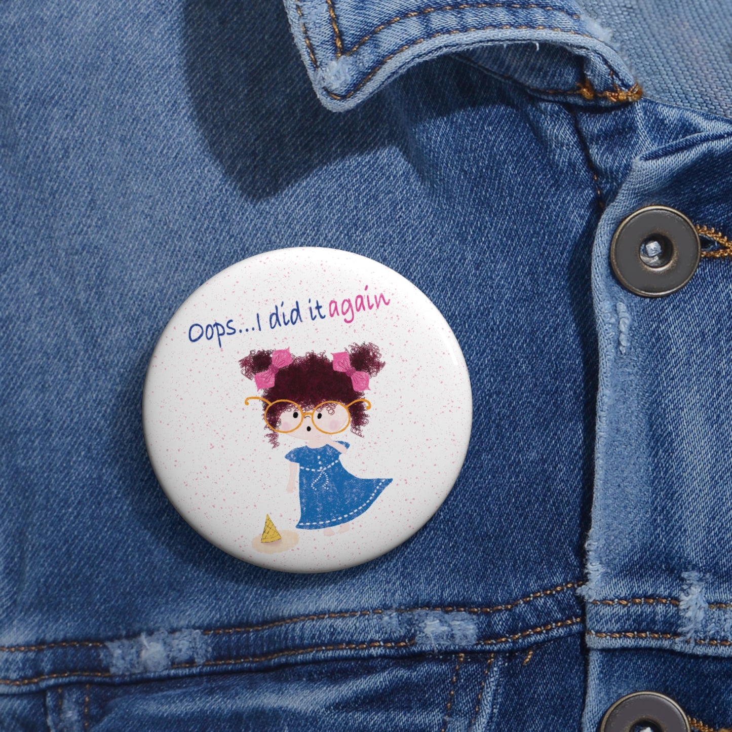 Humorous nursery round pin button featuring a cartoon girl with curly hair, oversized glasses, and a blue dress, standing next to a fallen ice cream cone, with the text 'Oops... I did it againâ, size 2.25â, close-up, kidlic