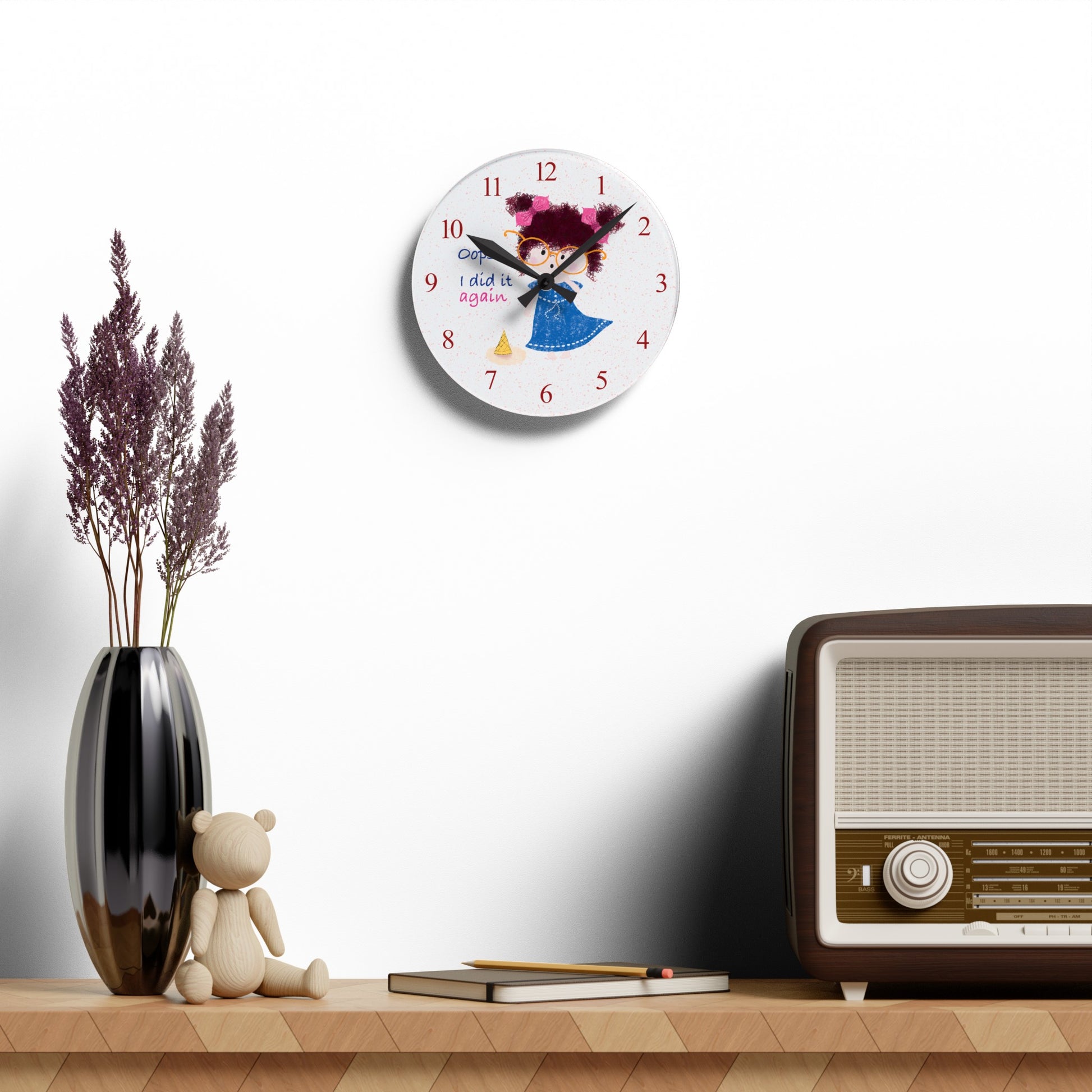 Charming humorous acrylic wall clock hanging on a white wall featuring a cartoon girl with curly hair, oversized glasses, and a blue dress, standing next to a fallen ice cream cone, with the text 'Oops, I did it again' alongside red numbers on the clock face, size 8”x8” (round), kidlic