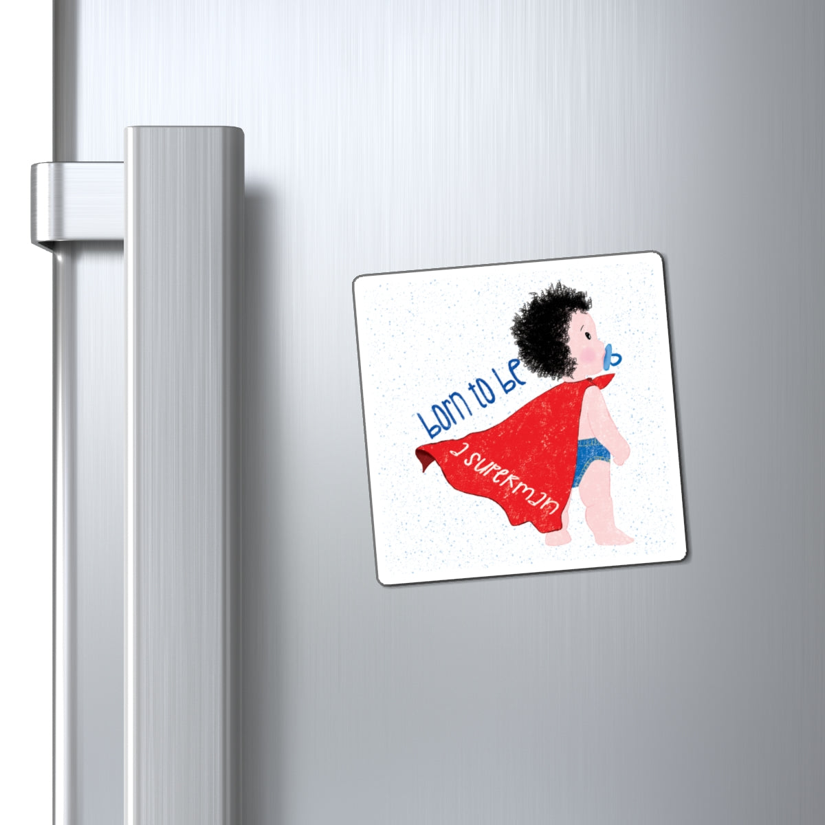 Playful (3”x3” size) fridge magnet featuring a cartoon baby with a pacifier, wearing a red cape, with the text 'Born to be a superman’, close-up, kidlic