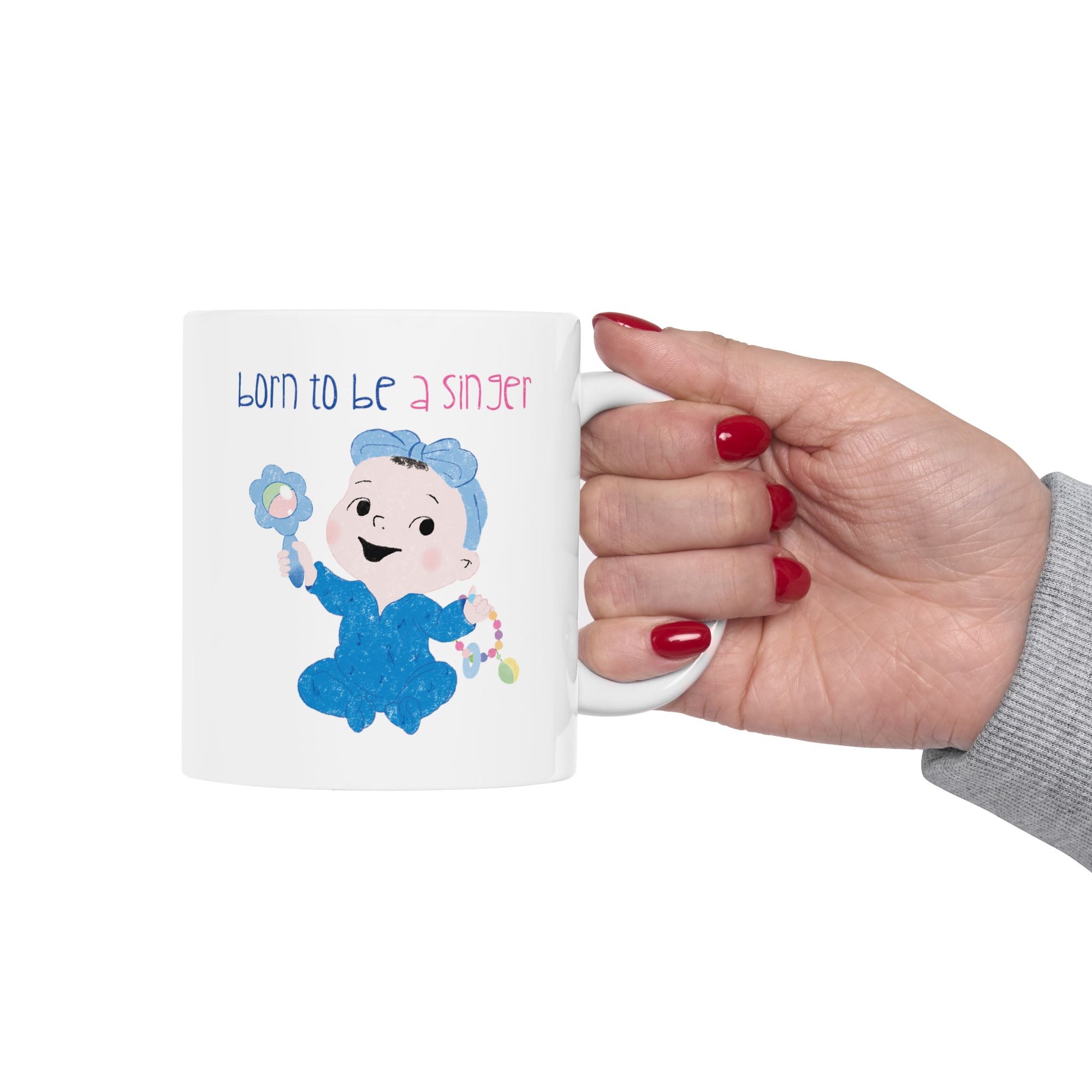 Adorable nursery coffee mug featuring a cartoon baby girl holding a rattle, with the text "Born to be a singer”, size: 11 oz, close-up, kidlic 