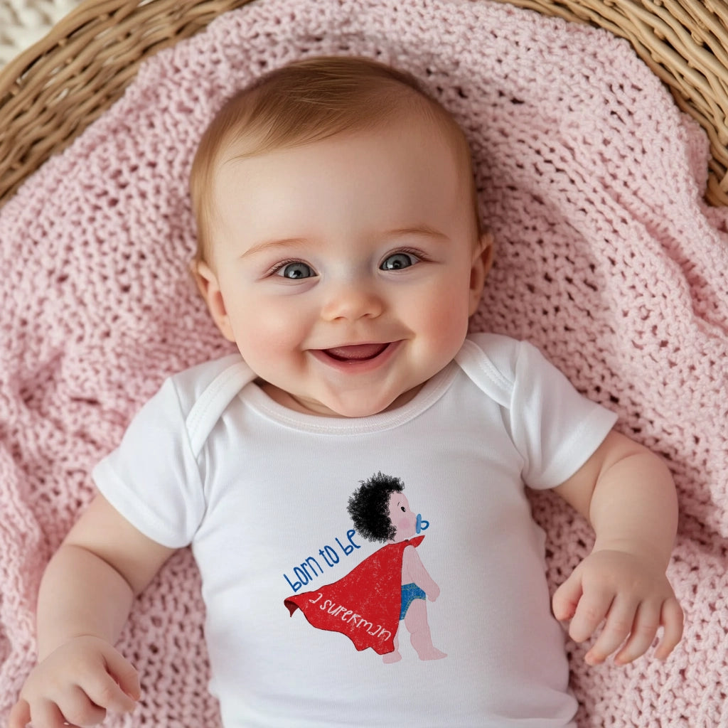 Baby in crib wearing Humorous Organic Baby Onesie featuring a cartoon baby with a pacifier, wearing a red cape, with the text 'Born to be a superman’, free shipping, kidlic