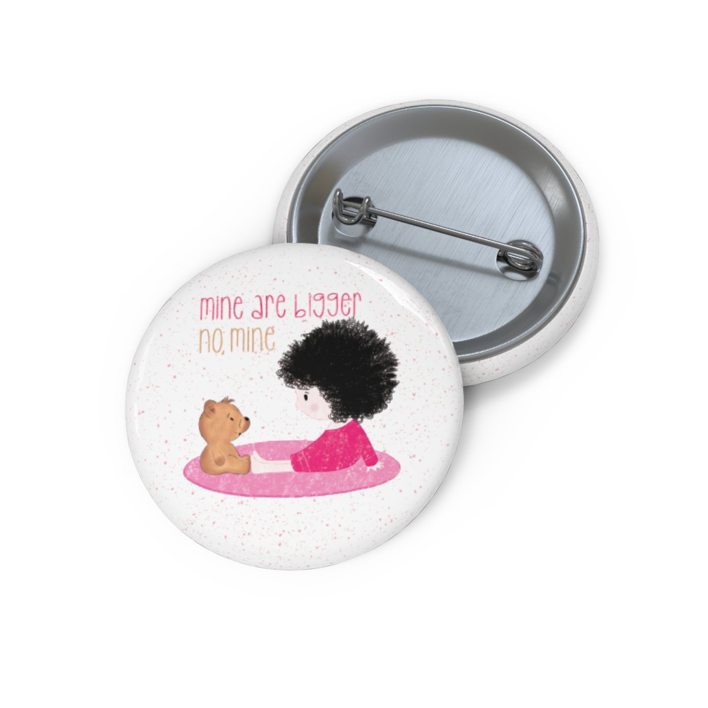 Playful nursery pin button featuring a cartoon child and a stuffed bear sitting on a pink mat, with the text 'mine are bigger,  no, mine’, size 1”, kidlic