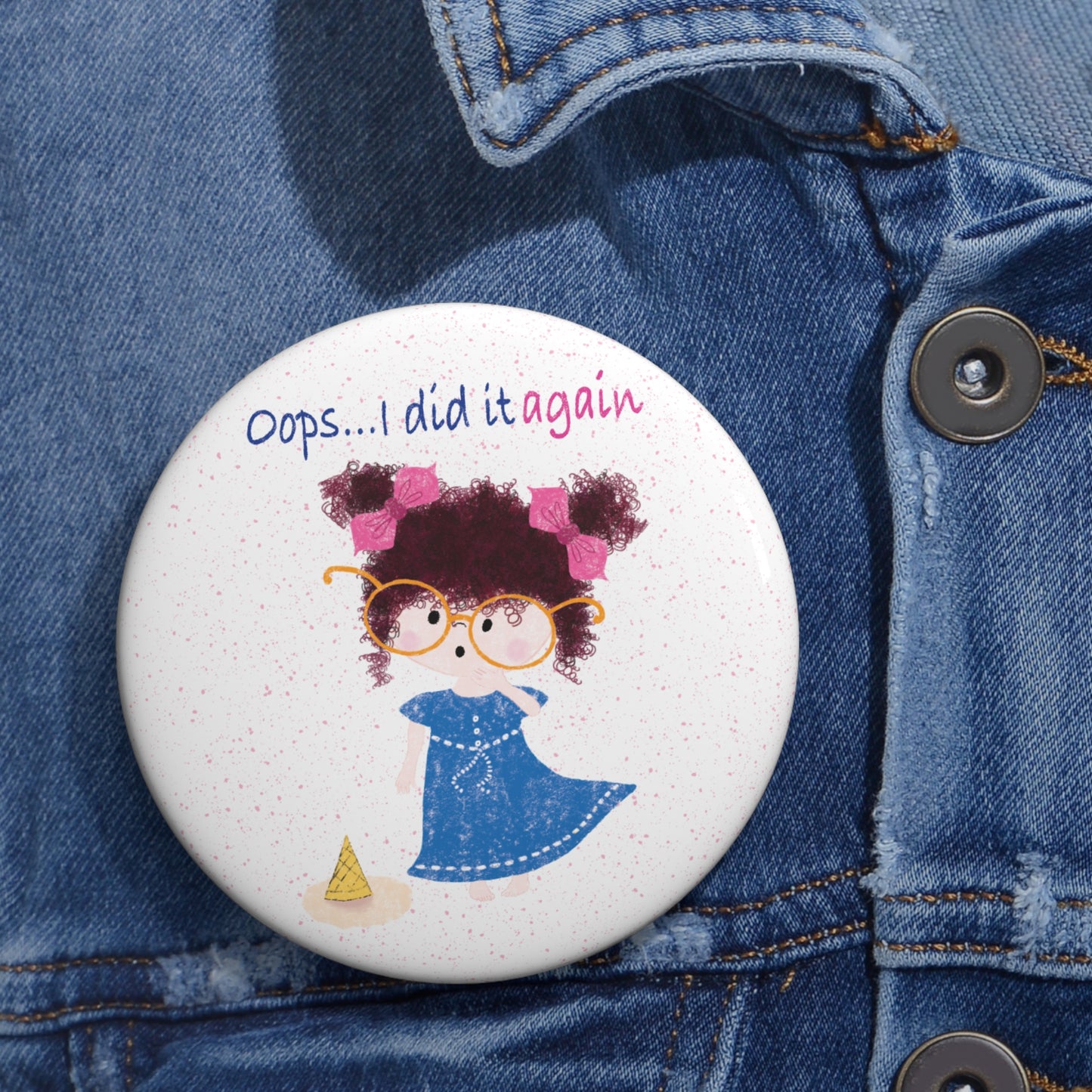 Playful nursery round pin button featuring a cartoon girl with curly hair, oversized glasses, and a blue dress, standing next to a fallen ice cream cone, with the text 'Oops... I did it again’, size 3”, close-up, kidlic