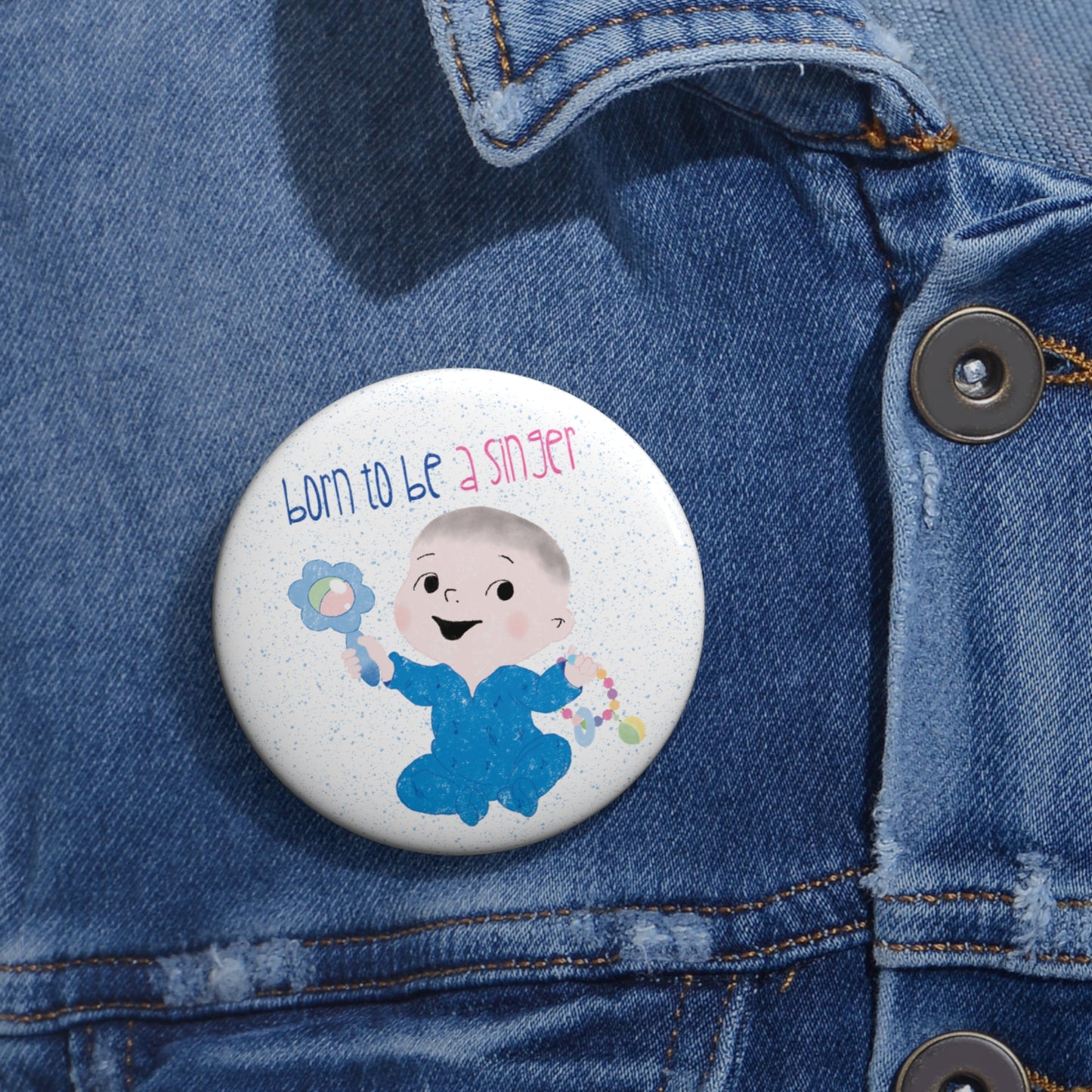 Playful baby nursery singer-themed pin button featuring a cartoon baby boy holding a rattle, with the text "Born to be a singer”, close-up, 2.25”, size, kidlic