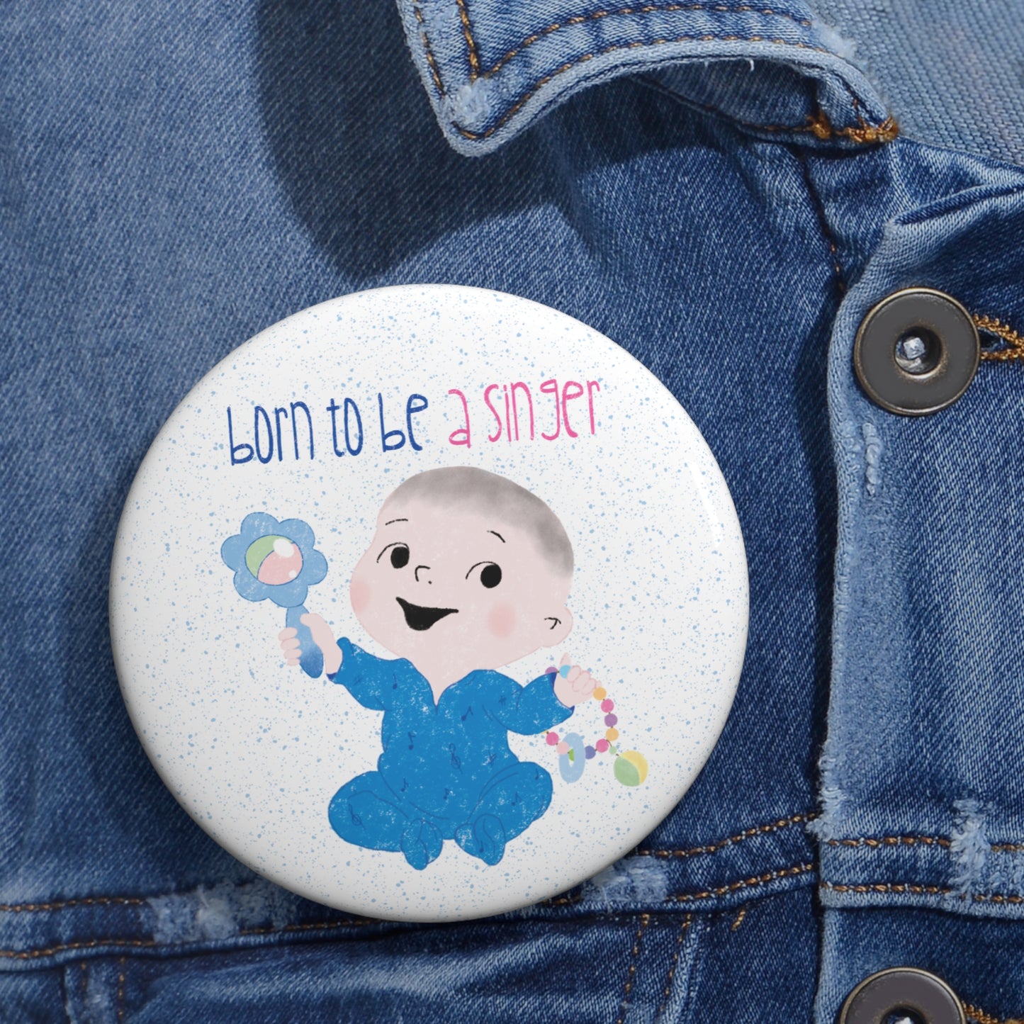 Hilarious baby nursery singer-themed pin button featuring a cartoon baby boy holding a rattle, with the text "Born to be a singer”, close-up, 3” size, kidlic