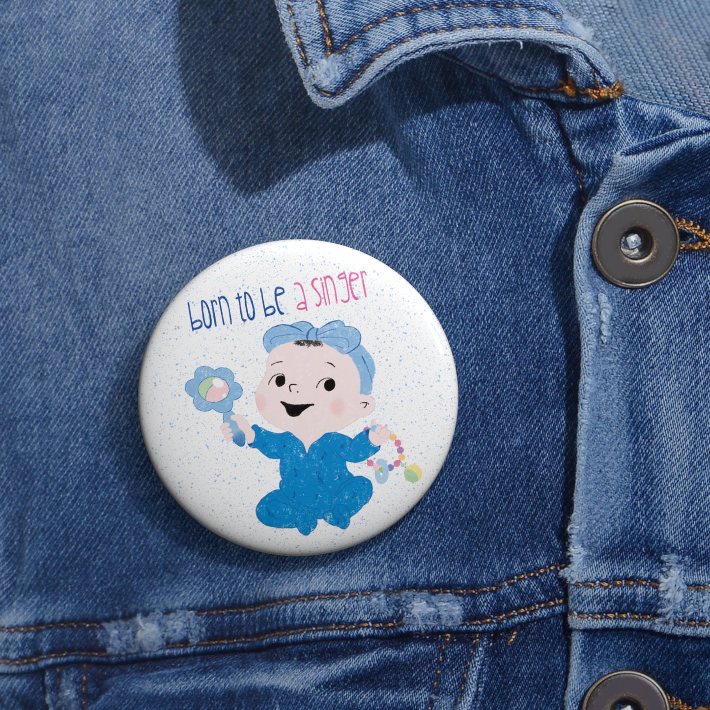 Playful nursery pin button featuring a cartoon baby girl holding a rattle, with a text “Born to be a Singer”, size 2.25”, close-up, free shipping, kidlic