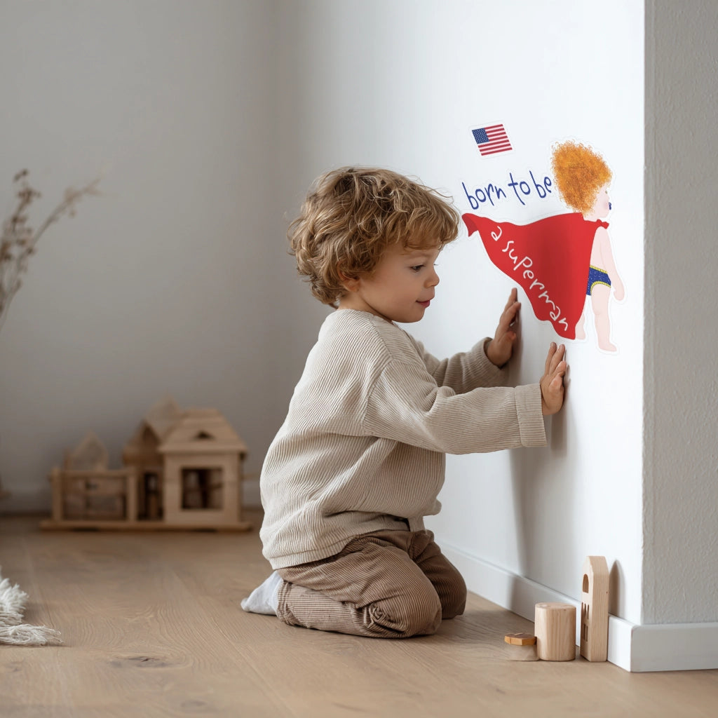 Child placing a superhero wall decal on a nursery wall during room decoration