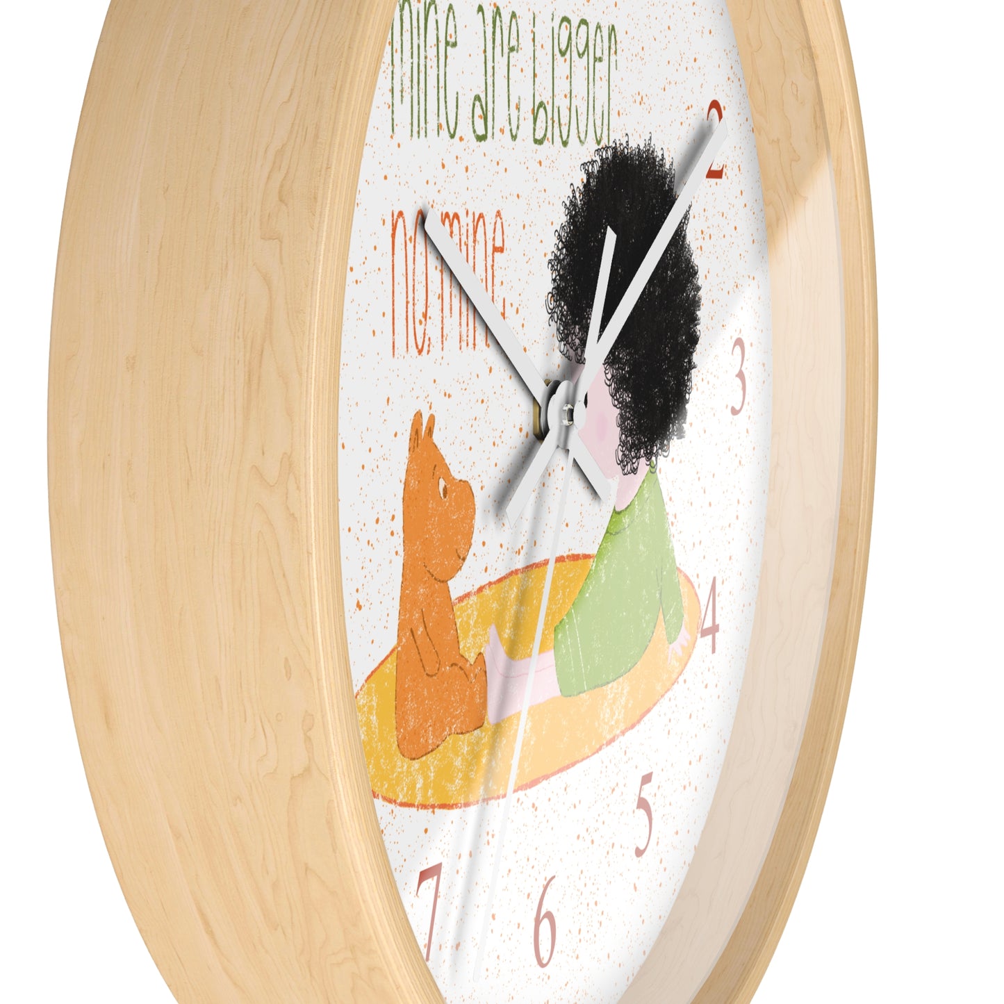 Funny 10” sized wooden round wall clock with white hands featuring a cartoon child sitting on a yellow mat, facing a stuffed bear, with the text 'mine are bigger' and 'no, mine,' and orange numbers on the clock face, close-up, kidlic