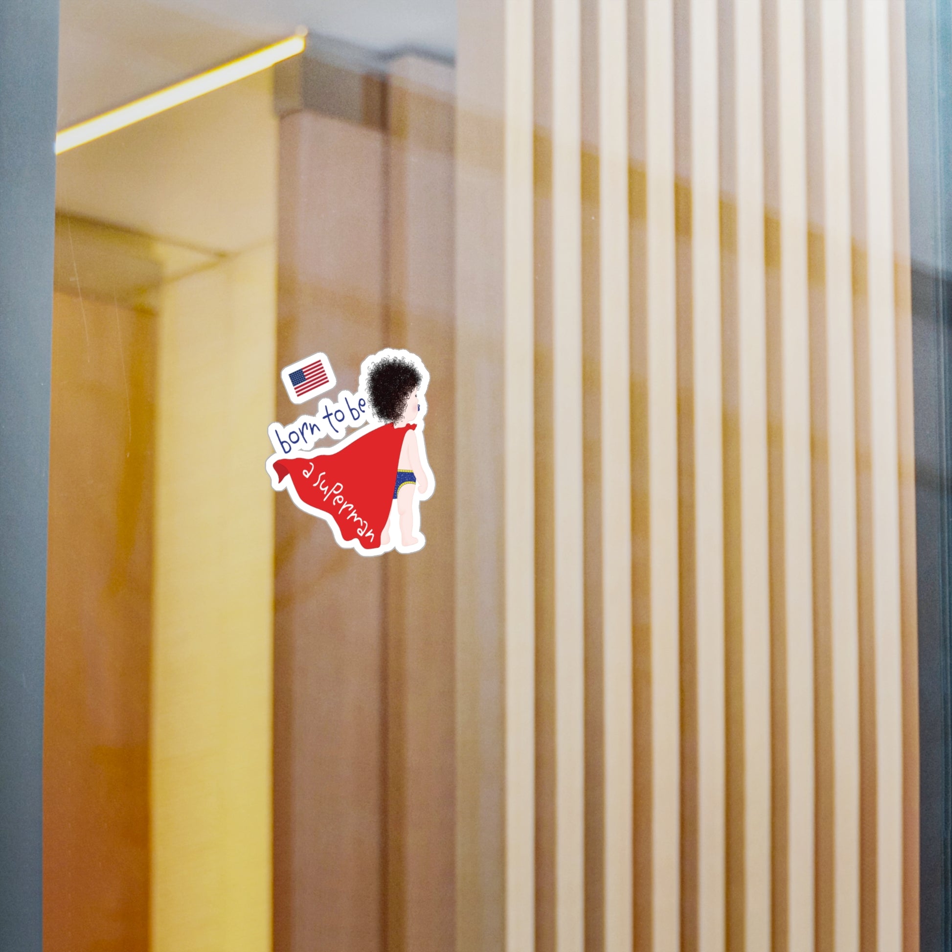 Dark-Haired Superman baby wall decal displayed on a glass wall in a modern nursery space