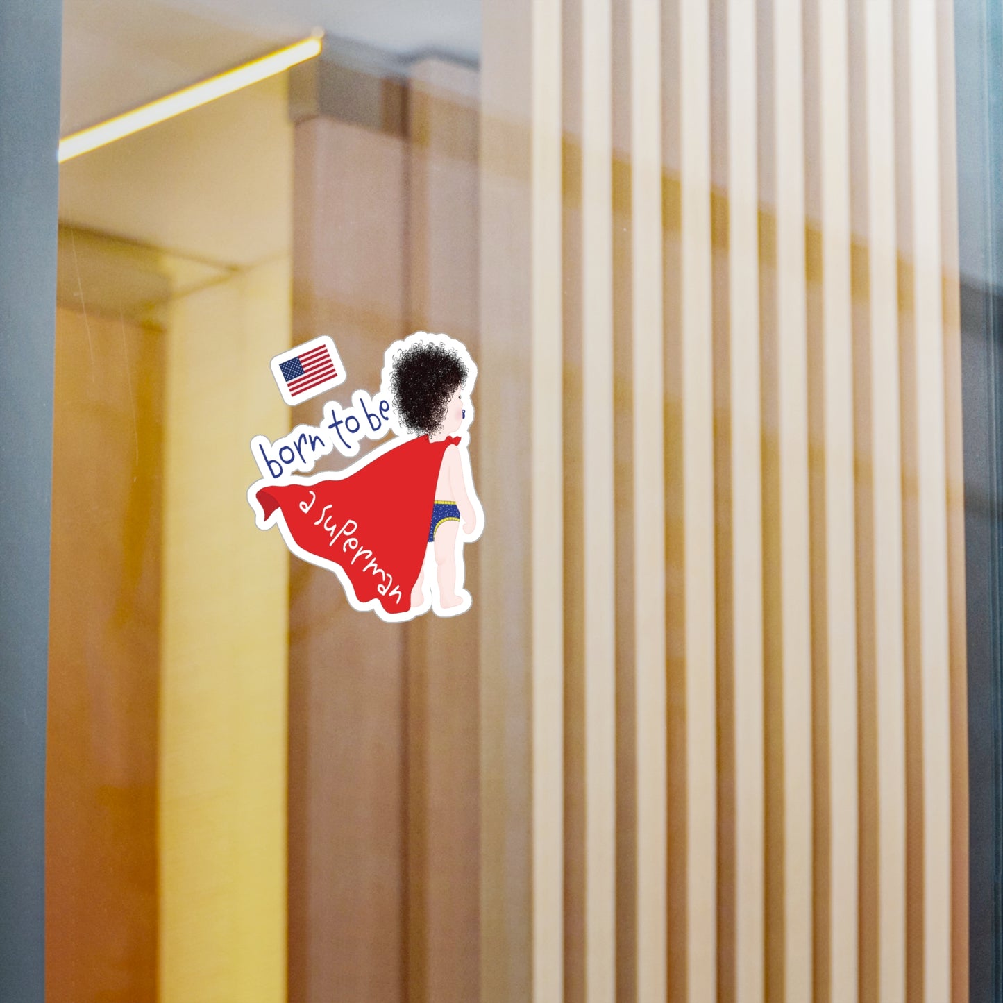Funny Superman baby wall decal applied to a glass surface, showing peel-and-stick nursery decor