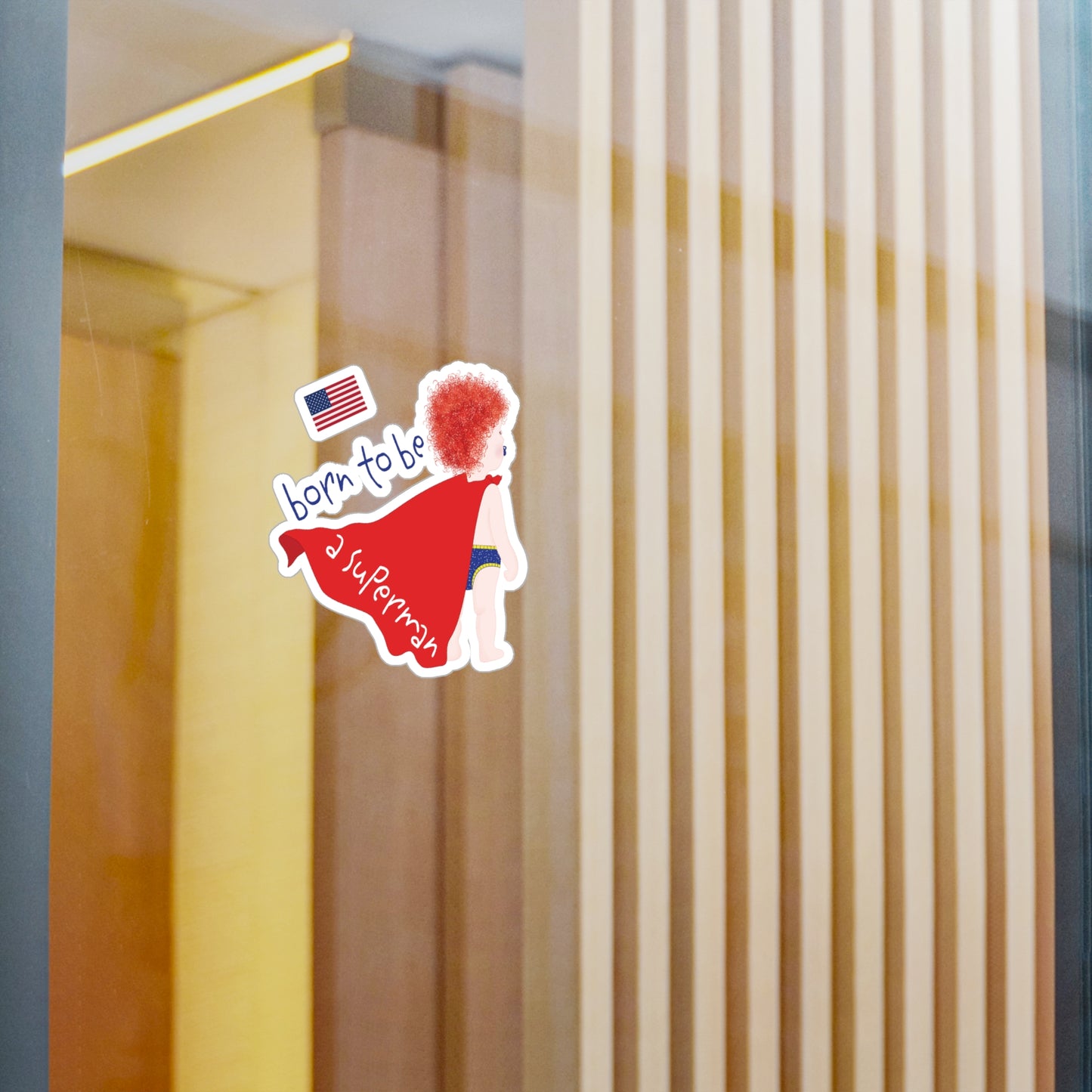 Redhead Superman baby wall decal displayed on a glass wall in a modern baby room space