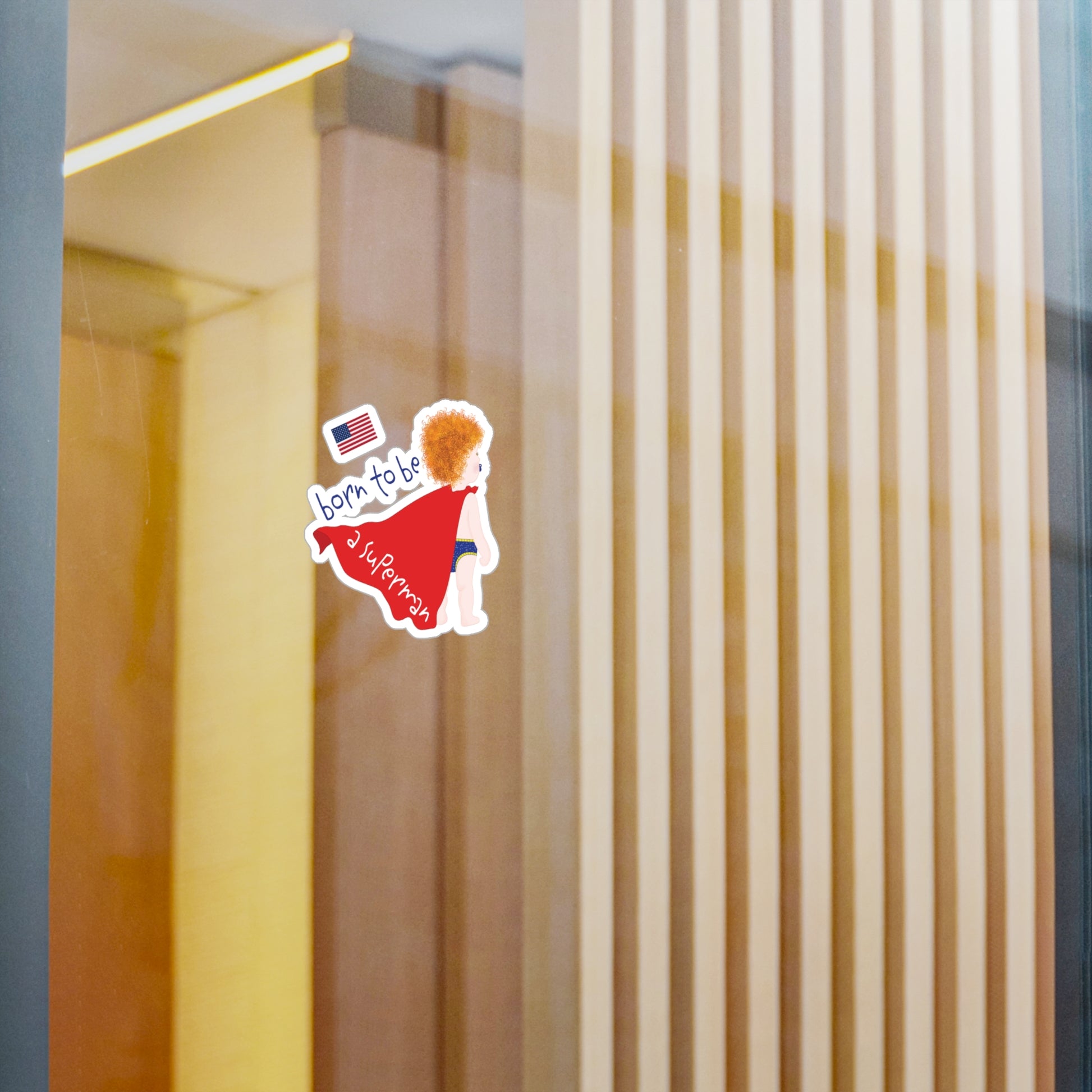 Redhead Superman baby wall decal displayed on a glass wall in a modern nursery space